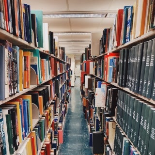 Hallway with bookshelves full of colorful books on both sides.